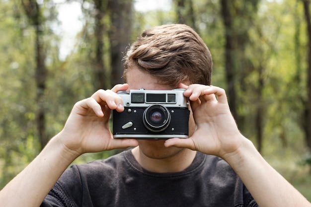 Foto grátis cara jovem, tirando fotos na floresta