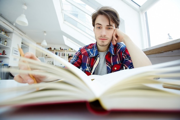 Foto grátis cara lendo na biblioteca