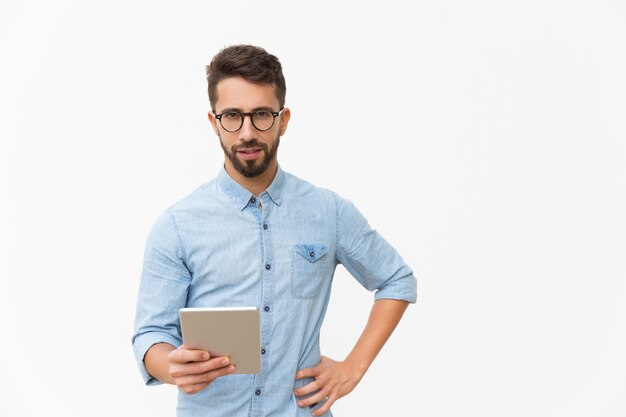 Cara pensativa usando tablet, segurando o dispositivo