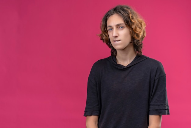 Foto grátis cara pensativo com cabelo comprido e camiseta preta na parede rosa