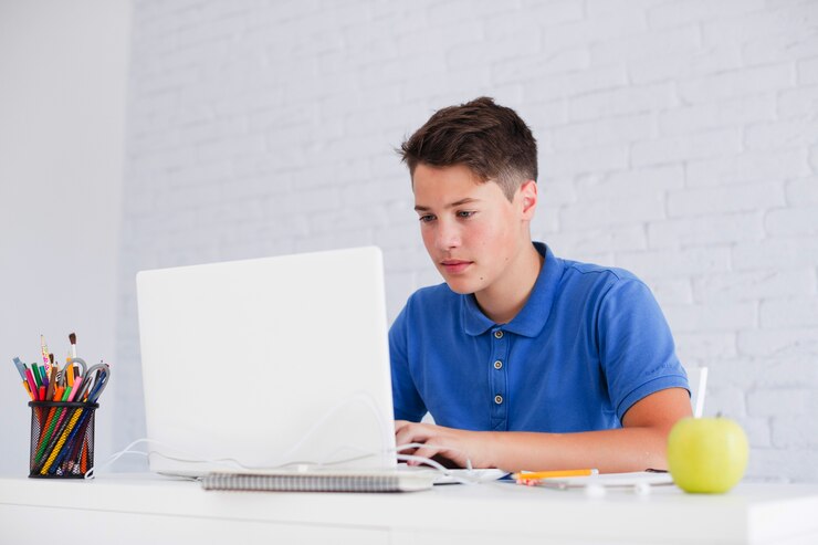 Foto grátis cara séria estudando com laptop na mesa
