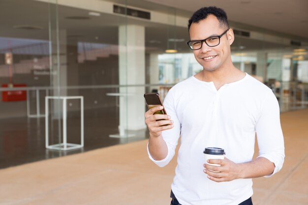 Cara sorridente com smartphone, olhando para a câmera