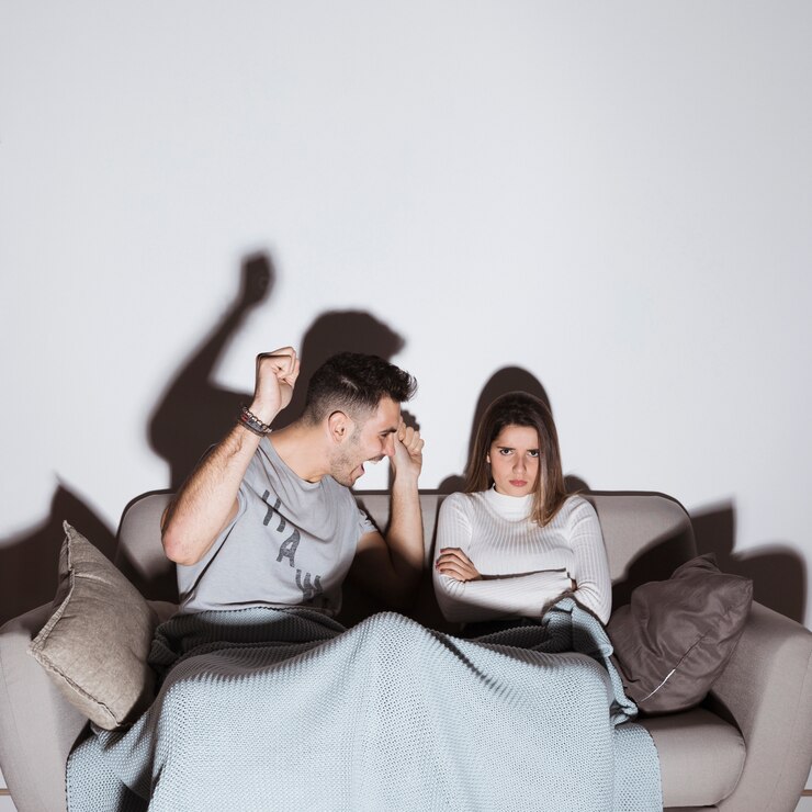 Foto grátis cara sorridente e com raiva senhora assistindo tv no sofá