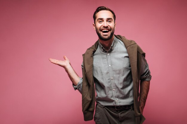 Cara sorridente olha para a câmera e demonstra lugar para texto em fundo rosa