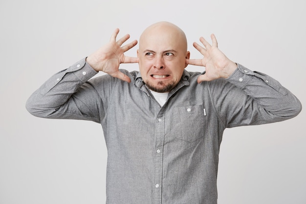 Foto grátis careca furioso e careca fechando os ouvidos do barulho alto