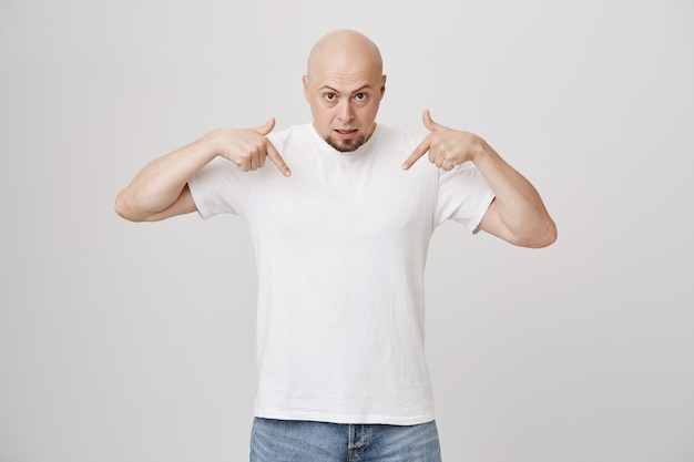 Careca surpreso apontando curioso