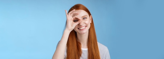 Foto grátis carismática feliz adorável ruiva adolescente olhos sinceros fazendo um show de olhos em círculo ok ok sinal del