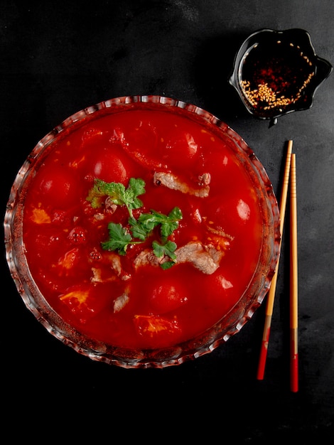 Carne com molho de tomate na mesa preta