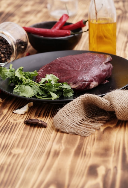 Carne crua com ingredientes para cozinhar a refeição