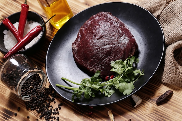 Carne crua com ingredientes para cozinhar a refeição