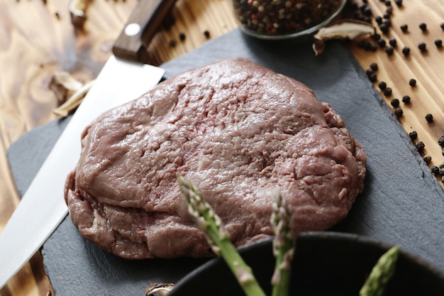 Carne crua com ingredientes para cozinhar a refeição