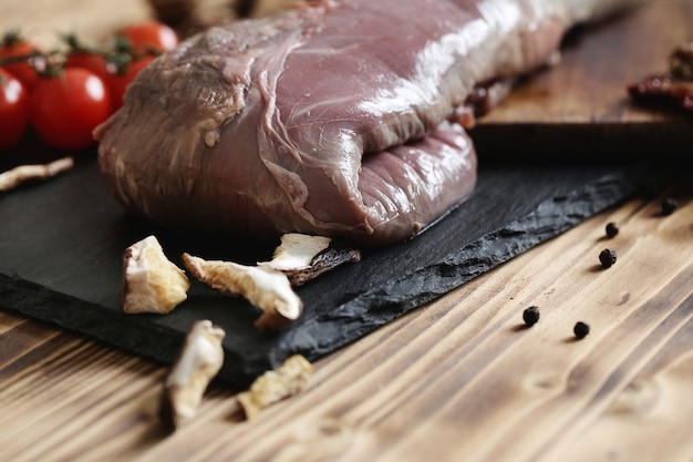 Carne crua com ingredientes para cozinhar a refeição