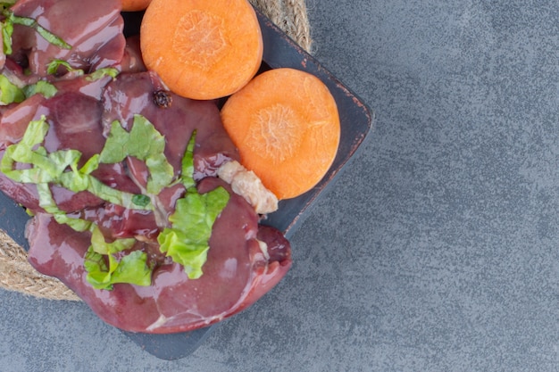 Foto grátis carne crua e legumes frescos no quadro escuro.