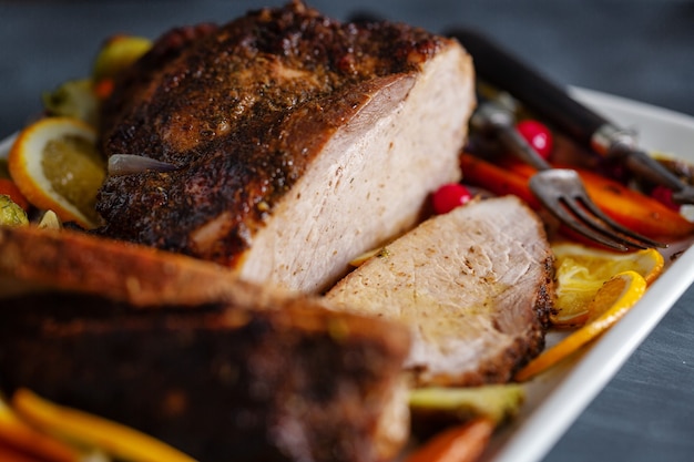 Carne de porco assada saborosa e apetitosa com legumes para o dia de Ação de Graças. Fechar-se.