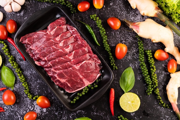 Foto grátis carne de porco crua fatiada usada para cozinhar com sementes de pimentão, tomate, manjericão e pimenta fresca.