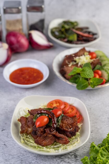 Carne de porco frita coberta com gergelim, colocado em um prato branco.