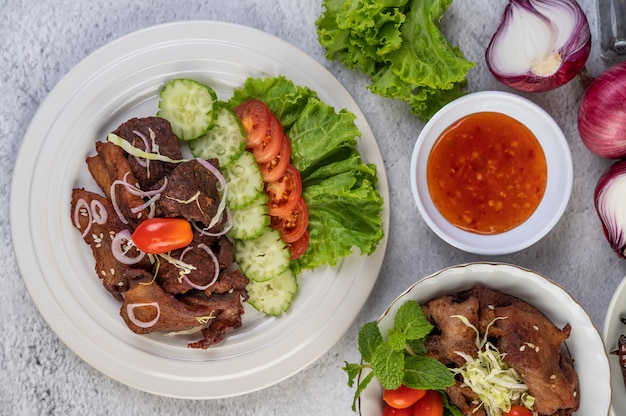 Foto grátis carne de porco frita coberta com gergelim, colocado em um prato branco.