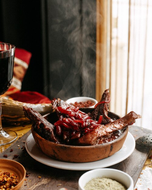 Carne frita com romã em cima da mesa