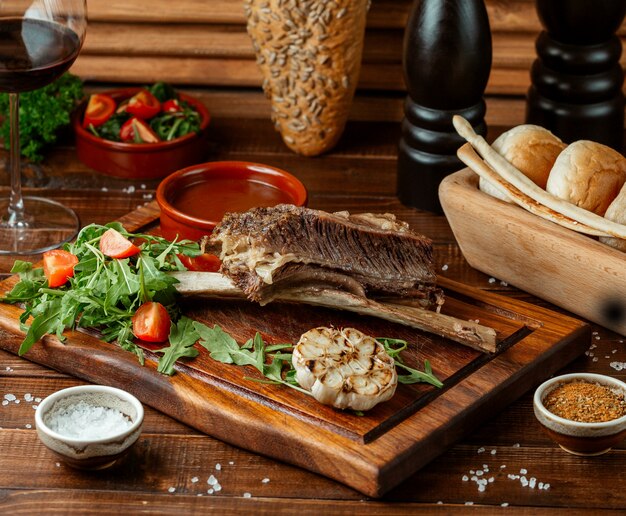 Carne frita com tomate na placa de madeira