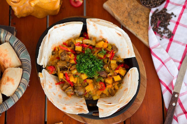 Foto grátis carne guisado de carne com batatas e legumes picados, servido com lavash.