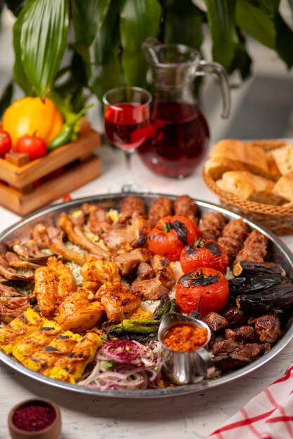 Carne, kebab de frango, churrasco com batatas assadas e grelhadas, tomate e arroz.