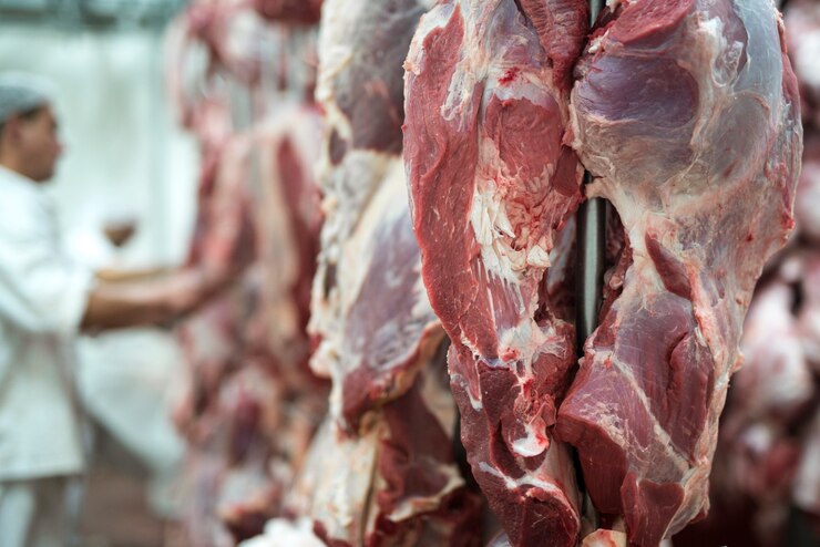 Foto grátis carne vermelha fresca e trabalhador de açougue trabalhando em segundo plano