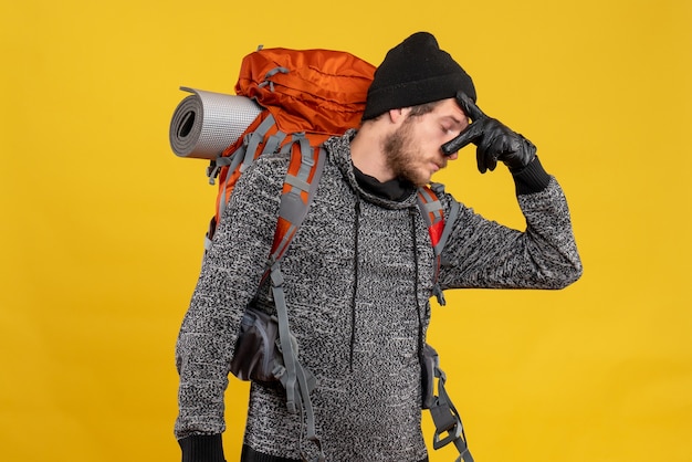 Foto grátis caroneiro masculino com luvas de couro e mochila segurando o nariz