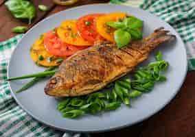 Foto grátis carpa de peixe frito e salada de legumes frescos na mesa de madeira.