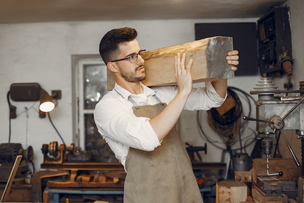 Carpinteiro considerável que trabalha com uma madeira