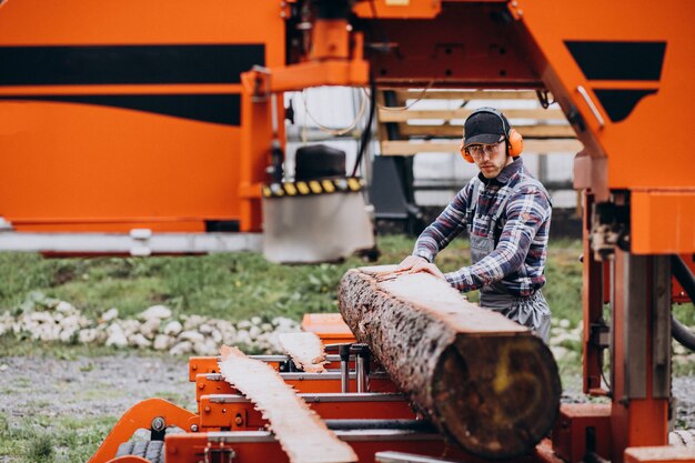 Carpinteiro trabalhando em uma serraria em uma fabricação de madeira