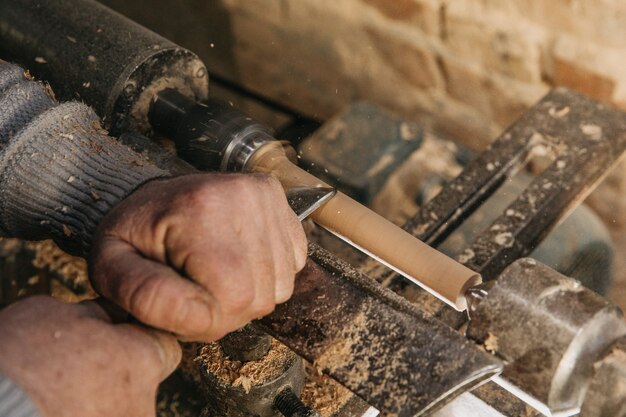 Carpinteiro usando madeira para fazer esculturas no ateliê