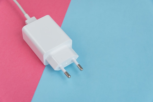 Carregador e cabo USB tipo C sobre fundo rosa e azul