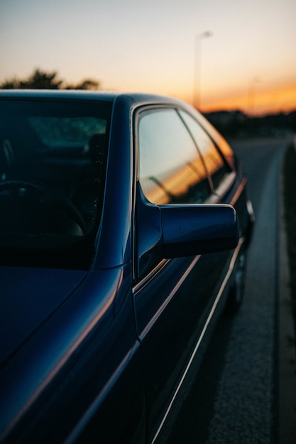 Carro com o céu do pôr do sol refletindo nas janelas