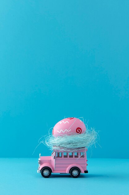 Carro de páscoa rosa com ovo e fundo azul