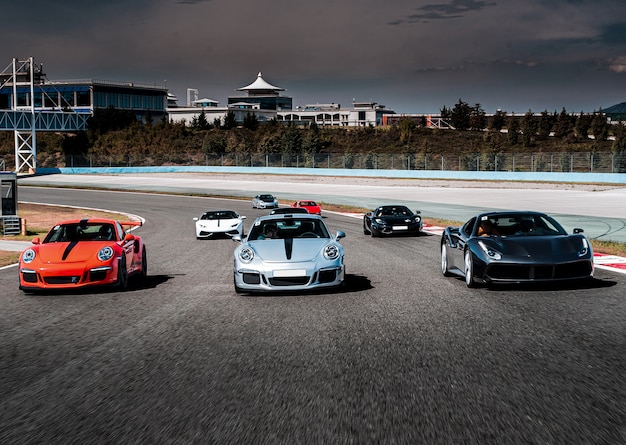 Carros esporte desfile ou corrida na estrada.