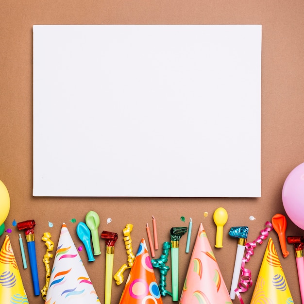 Foto grátis cartão em branco branco com objetos de aniversário em pano de fundo marrom
