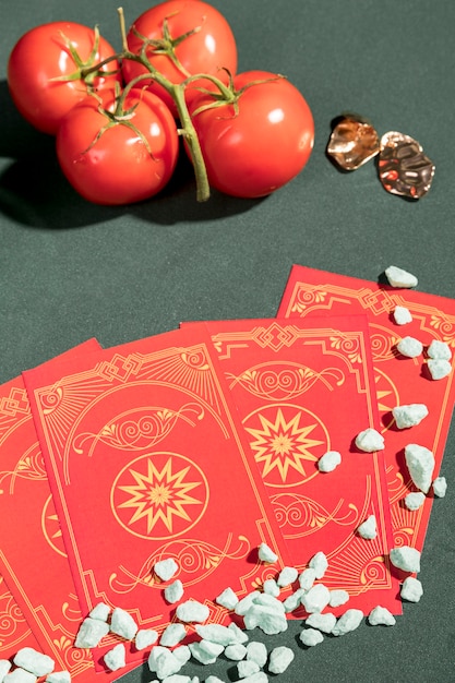 Cartas de tarô de alto ângulo ao lado de tomates