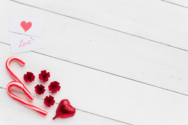 Foto grátis cartões com título de amor perto de coração decorativo e bastões de doces
