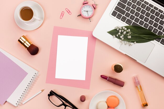Cartões em branco com produtos de maquiagem, biscoitos, despertador, xícara de café e laptop em pano de fundo colorido