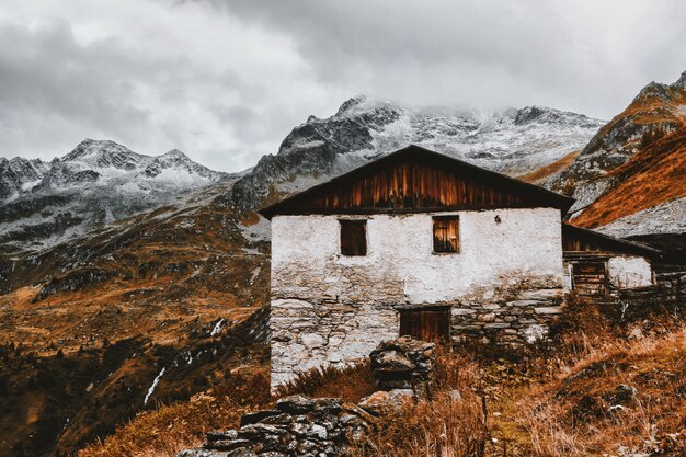 Casa branca e marrom perto de montanhas cobertas de neve