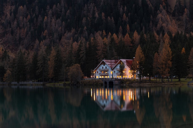 Casa branca e vermelha, cercada por árvores à noite