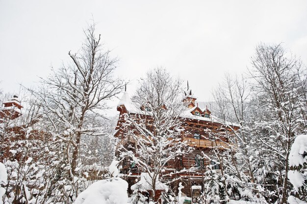 Casa de madeira na floresta de pinheiros coberta de neve Lindas paisagens de inverno Natureza geada