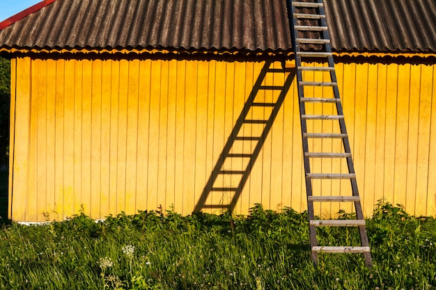 Casa rural amarela bonita com escadas de madeira na zona rural.