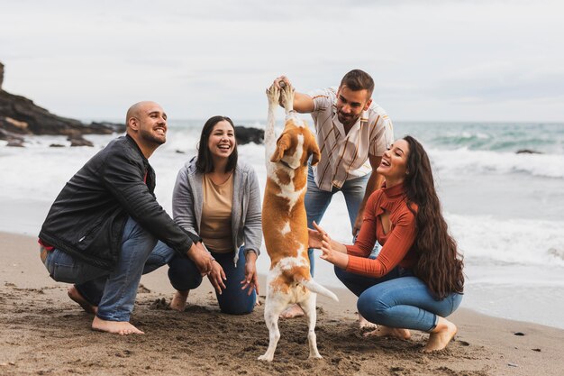 Casais com cachorro na beira-mar