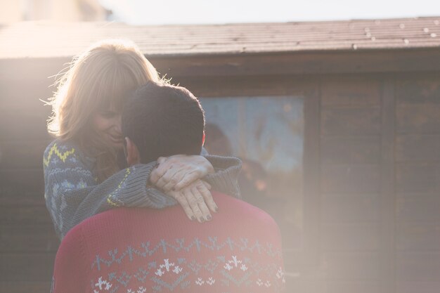 Casal abraçando na parede de madeira