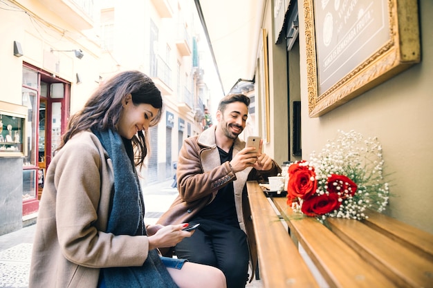 Casal acessando smartphones na data