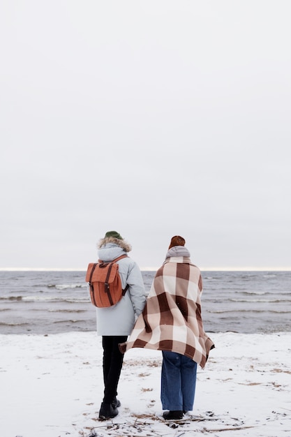 Foto grátis casal acordando na praia durante uma viagem de inverno