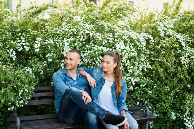 Casal adorável aproveitando o tempo livre no parque sentado no banco