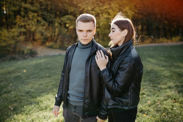 Casal adorável posando na floresta de outono, amantes caminhando no parque