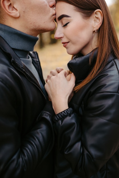 Casal adorável posando na floresta de outono, amantes caminhando no parque